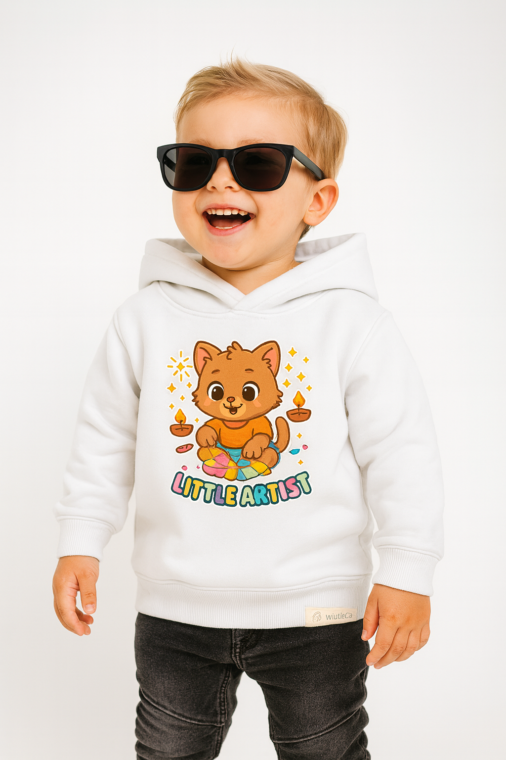 Imaginative toddler wearing Little Artist kitten hoodie (0−6 yrs) on white fabric.