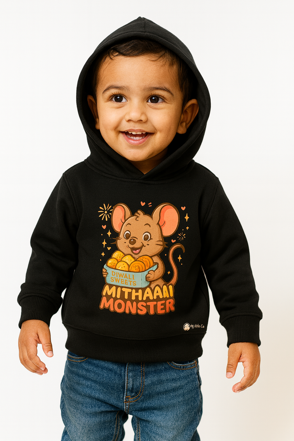 Smiling toddler wearing Mithai Monster mouse hoodie holding laddoos (0−6 yrs).