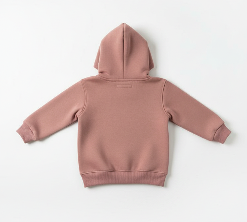 Unisex kid modeling trendy Peach winter hoodie. Stylish fit for festive photos.